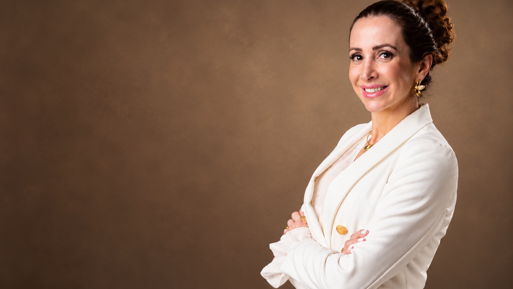 Camila, profissional responsável pelos cuidados da Drena, sorrindo de blazer branco